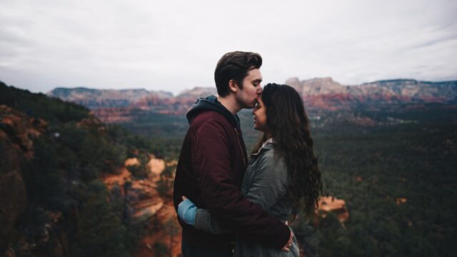 man kissing woman's forehead