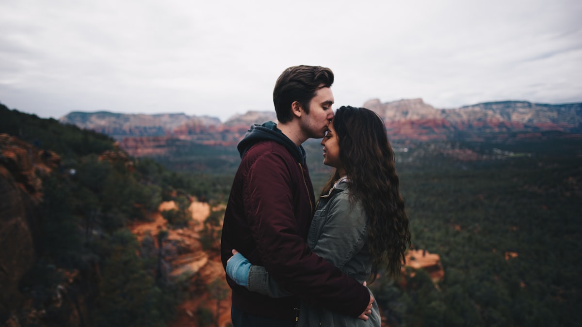 man kissing woman's forehead